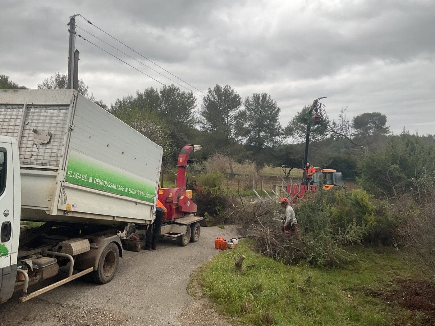 Camion benne et broyeur Majuro en bord de route pendant le rabattage d’une grande haie