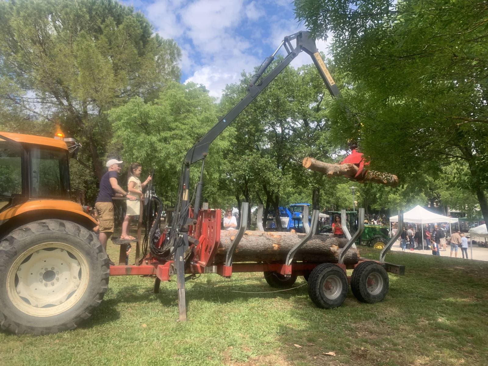 Tracteur Majuro et remorque forestière chargeant une grume au salon de la ruralité